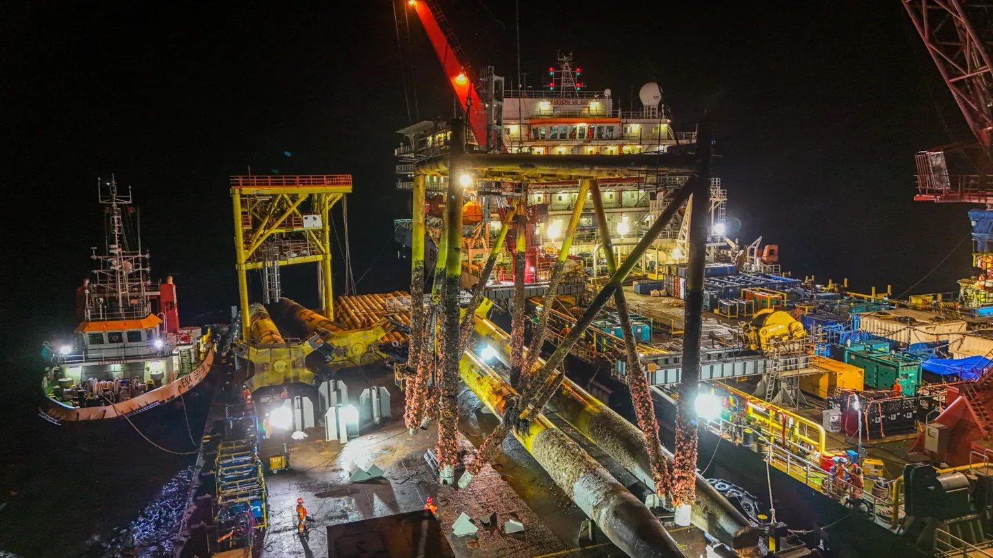 Illuminated offshore platform and working vessels at night