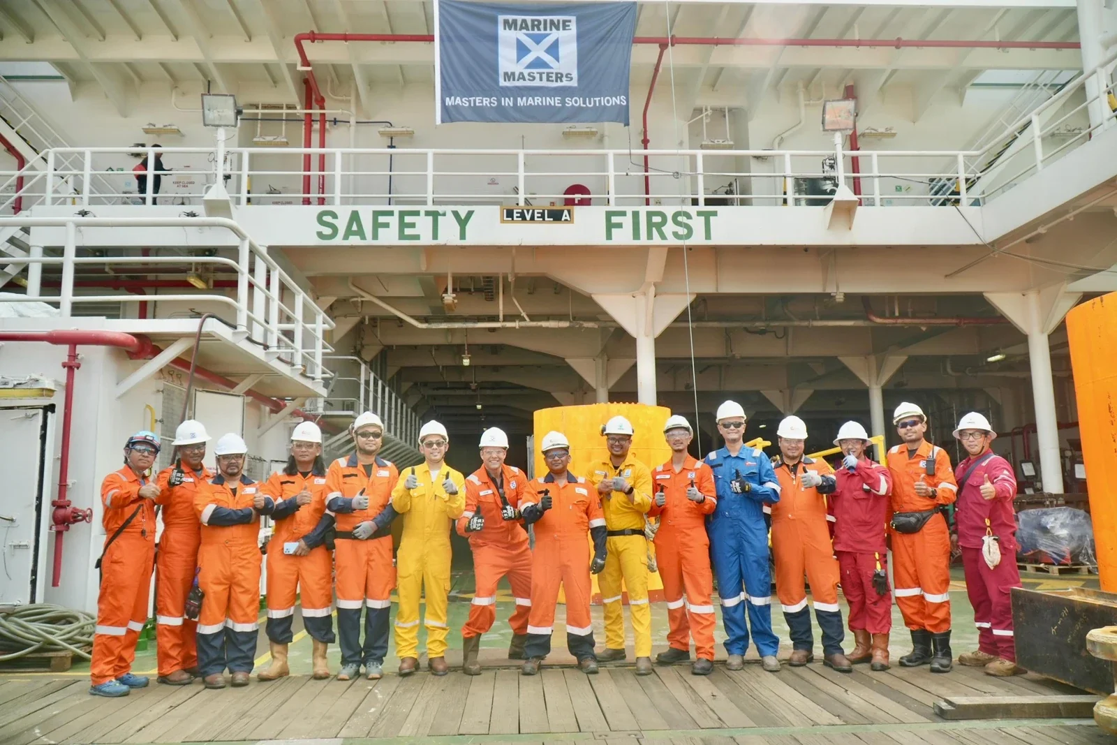Marine Masters offshore team wearing PPE on a vessel deck beneath Safety First signage